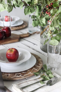 A picture showing a fall table setting with apples.