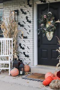 A picture of a front porch with black bats hanging from the siding.