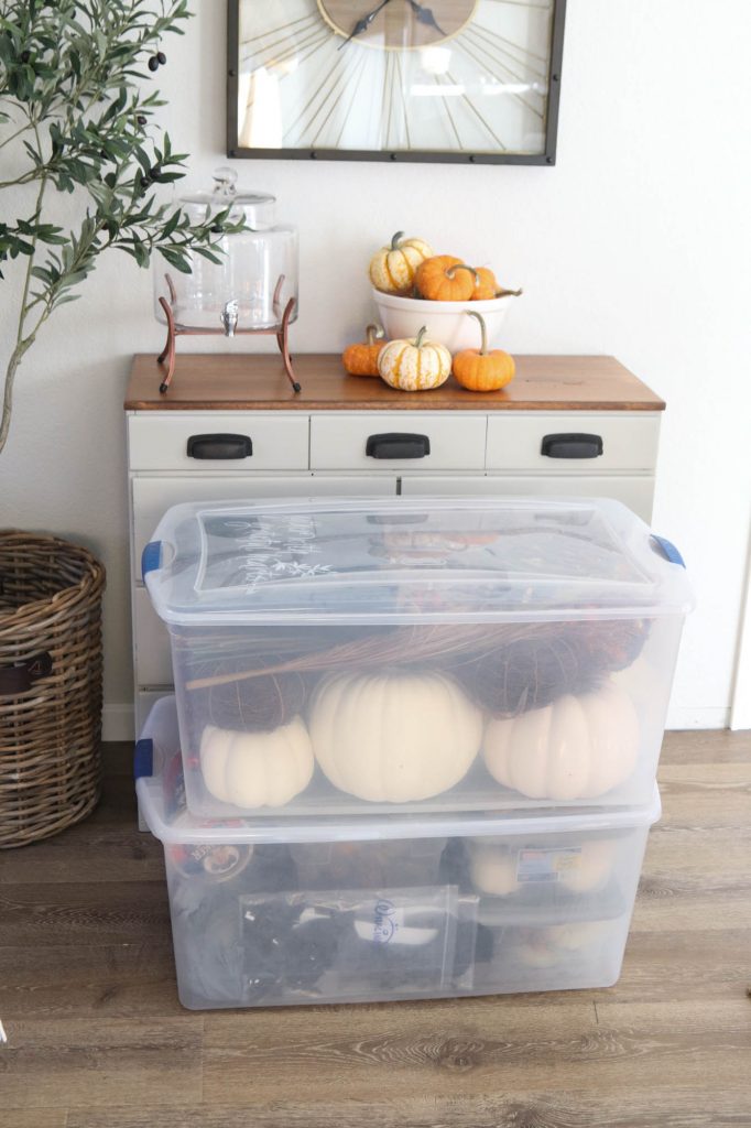 A picture of two storage totes filled with fall decor.