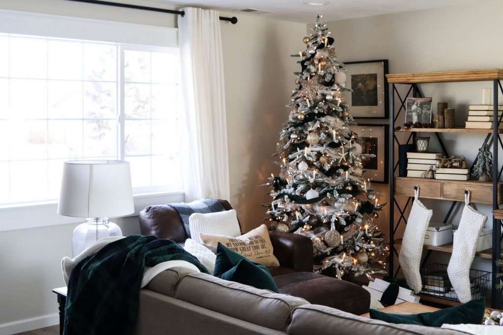 A picture of a living room with a Christmas tree and couch. 