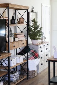 A picture of bookshelves, a dresser and a mini Christmas tree.