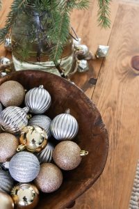 A picture of Christmas ornaments in a wooden bowl.