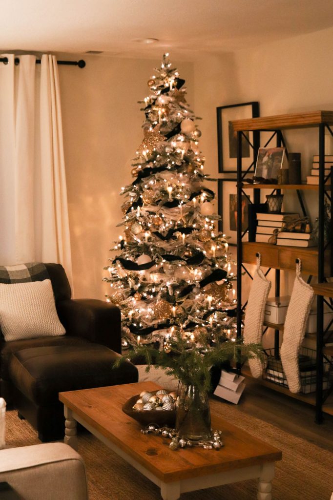 A picture of a living room with a Christmas tree lit up.