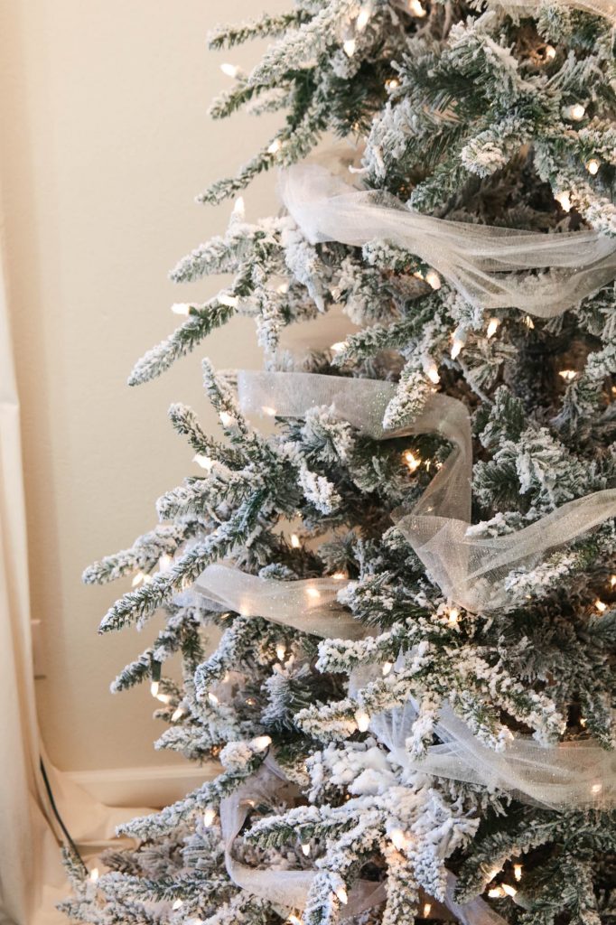 A picture of a flocked Christmas tree with garland.