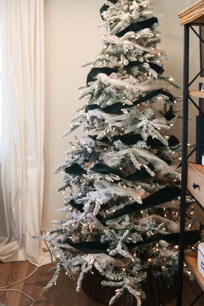 A picture of a flocked Christmas tree with garland.