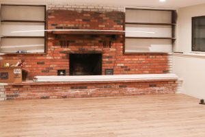 A picture of a large brick fireplace.