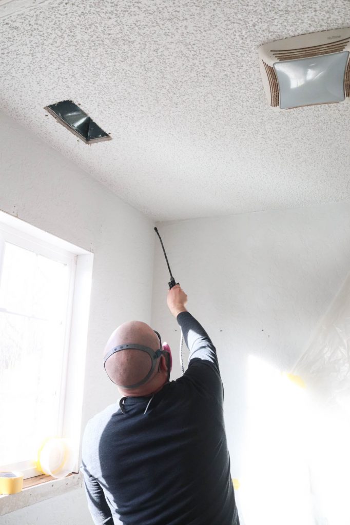 A picture of Todd removing the popcorn ceiling.