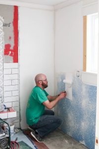 A picture of Todd painting the bathroom walls.