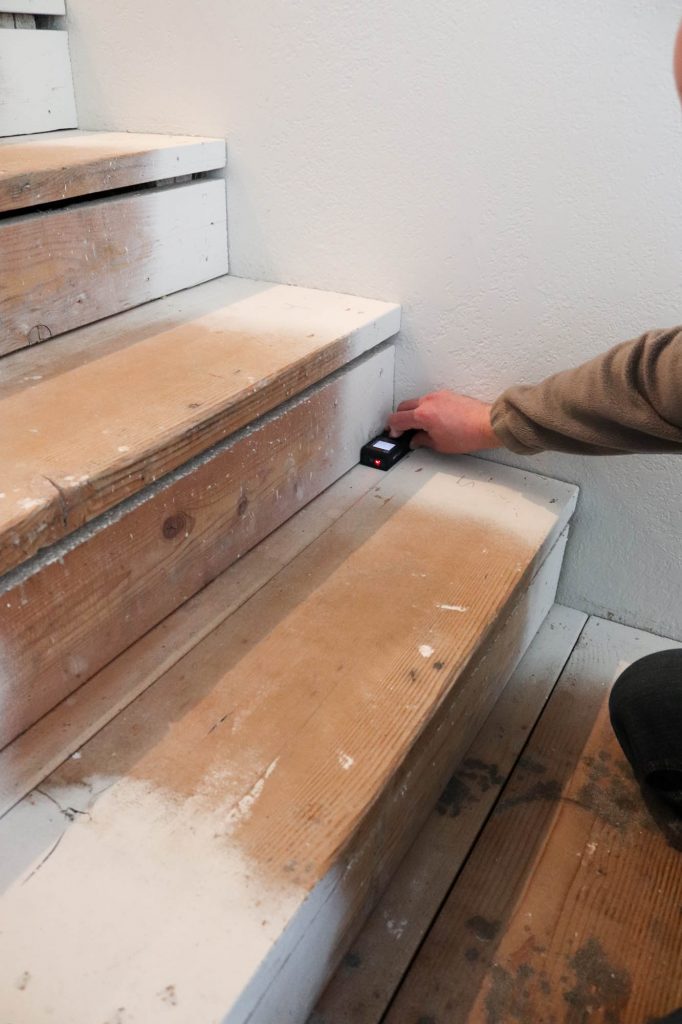 A picture showing Todd measuring each stair step. 