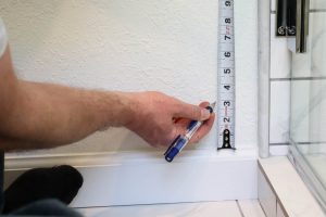 A picture showing Todd measuring up the wall 3".