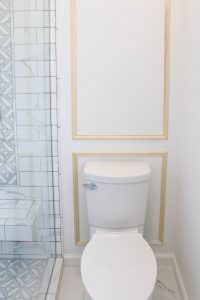 A picture of the toilet wall with moulding installed.