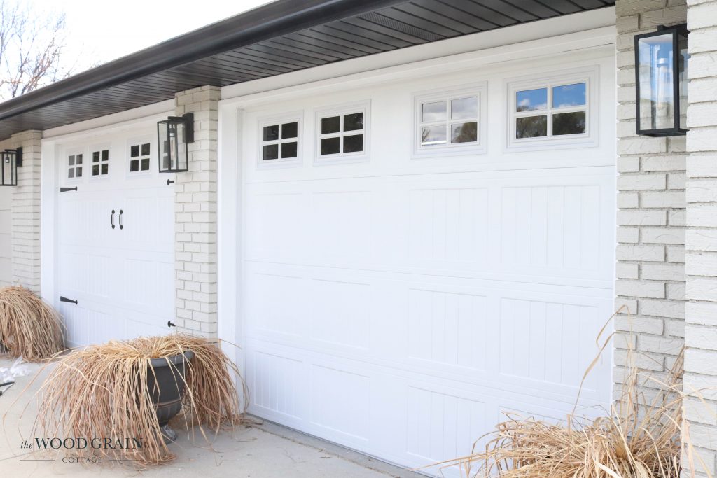 A picture of the new garage doors with hardware being installed. 