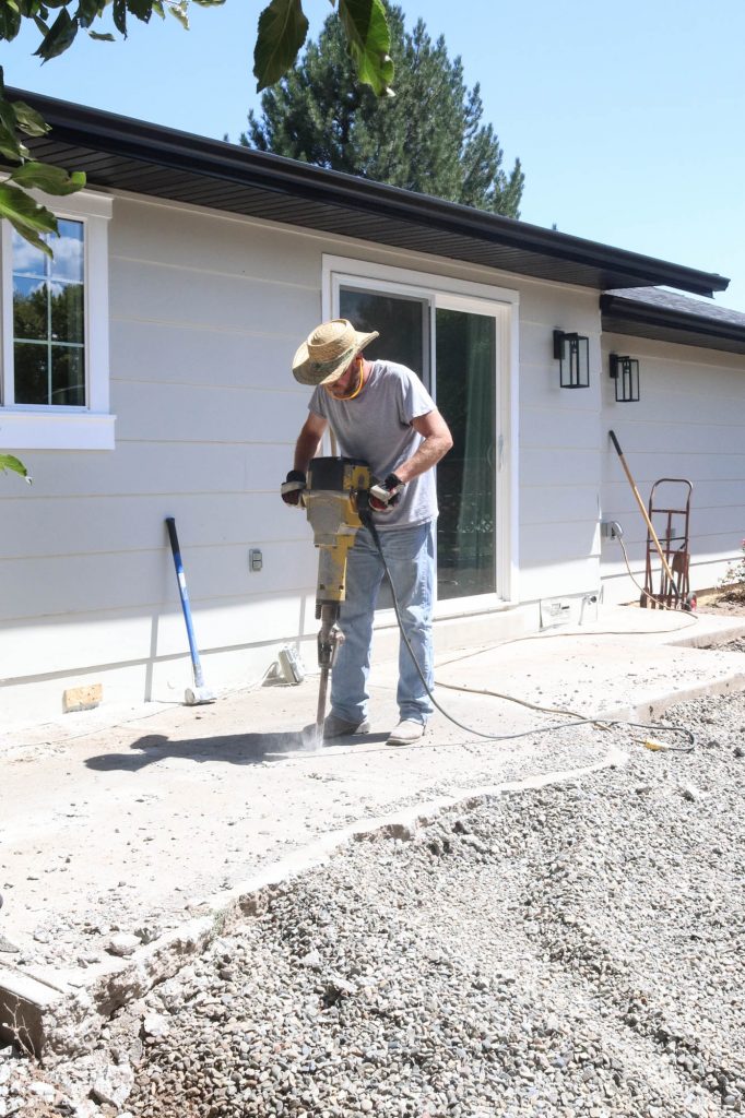 A picture of Todd jack hammering the concrete. 