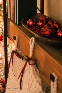 A picture showing our stockings and a bowl full of red ornaments.
