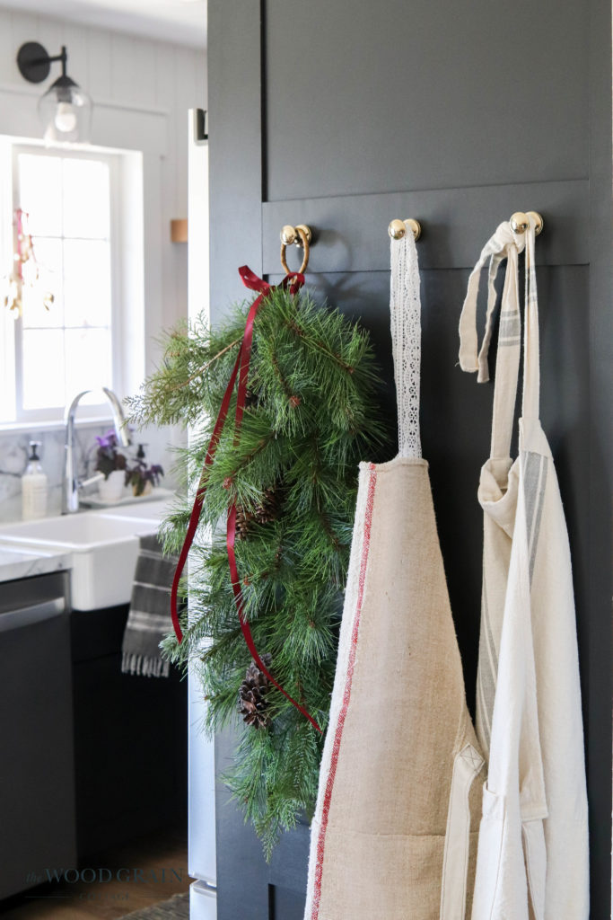 A picture of faux greenery hanging with aprons.