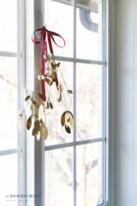 A picture of mistletoe hanging in the kitchen window.