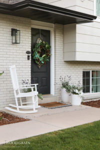 A picture of our front porch with the lavender pots and a white rocking chair.