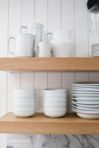 A picture of our open shelves with white dishes.